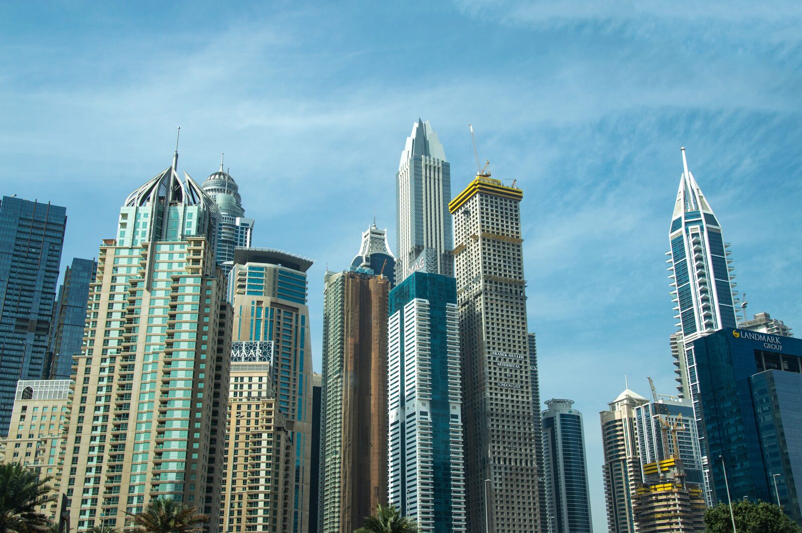 Sunlit Dubai towers against a blue sky